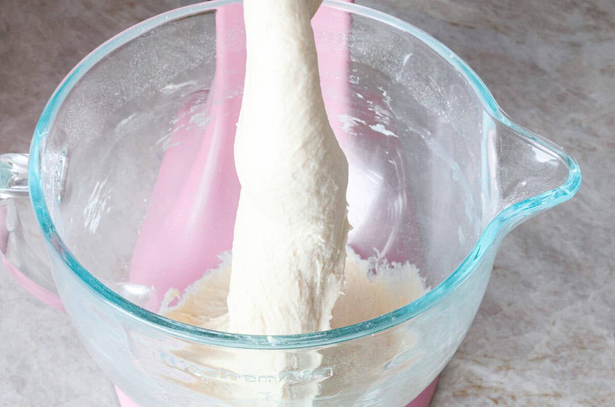 Angle shot of dough being mixed in stand mixer. 