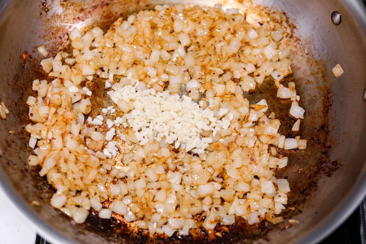 There's no need to purchase store-bought sauce, with this hearty and flavorful Homemade Spaghetti Sauce. Simple ingredients such as ground beef, onion, garlic, and spices of oregano and basil bring a bold flavor to this simple sauce. Second photo of the onion and garlic cooking in a pan.