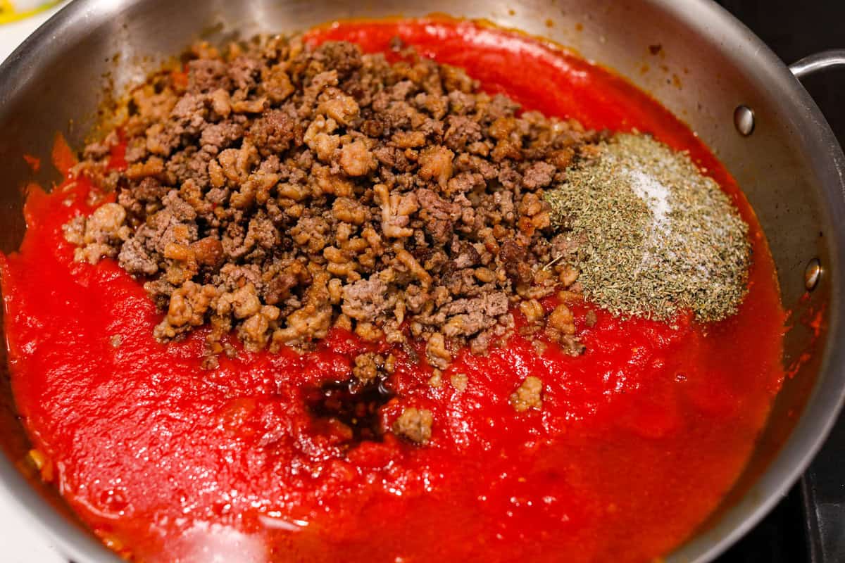 There's no need to purchase store-bought sauce, with this hearty and flavorful Homemade Spaghetti Sauce. Simple ingredients such as ground beef, onion, garlic, and spices of oregano and basil bring a bold flavor to this simple sauce. Third photo of the cooked meat mixture and seasonings added to the sauce.