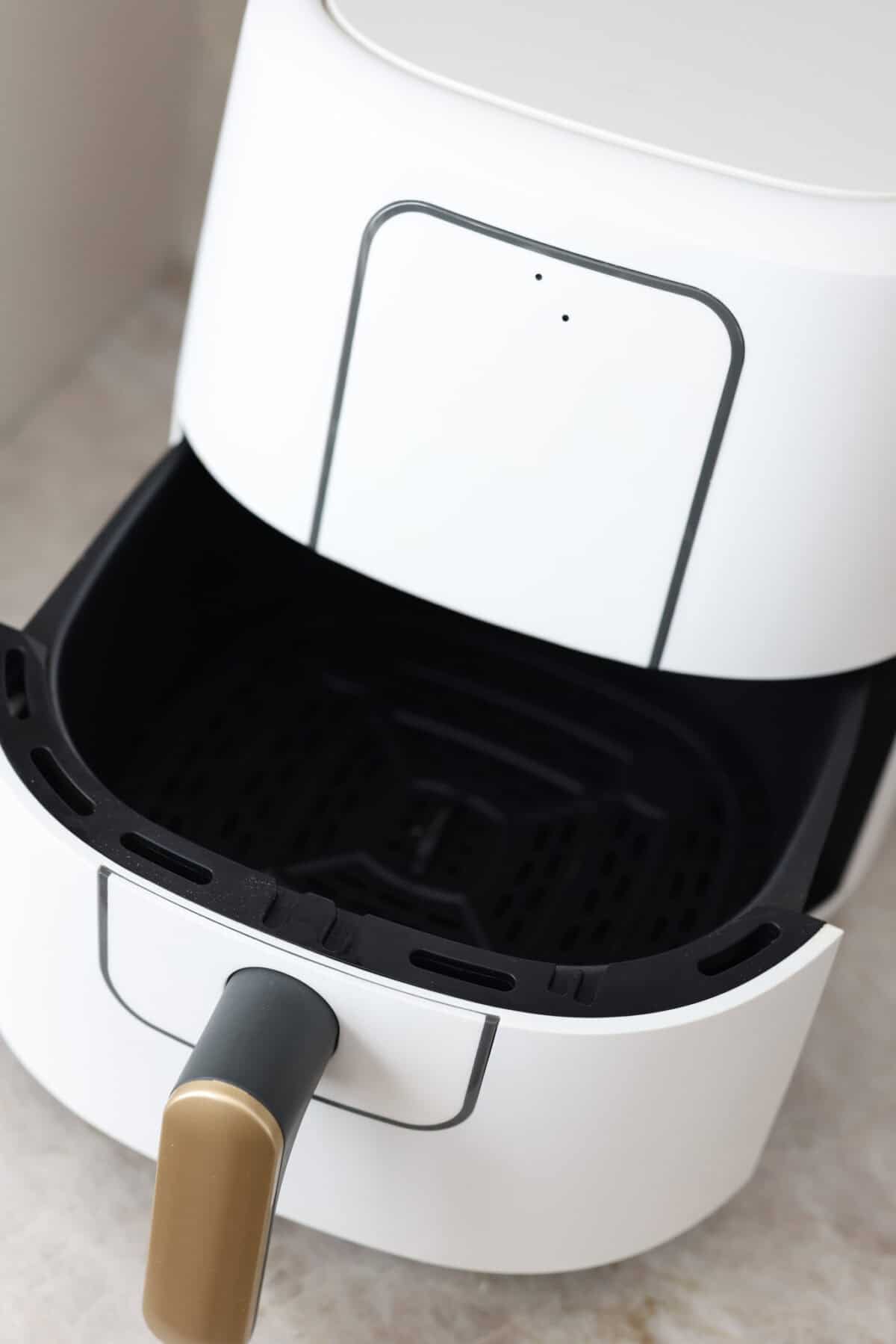 Close view of an air fryer with the basket open.