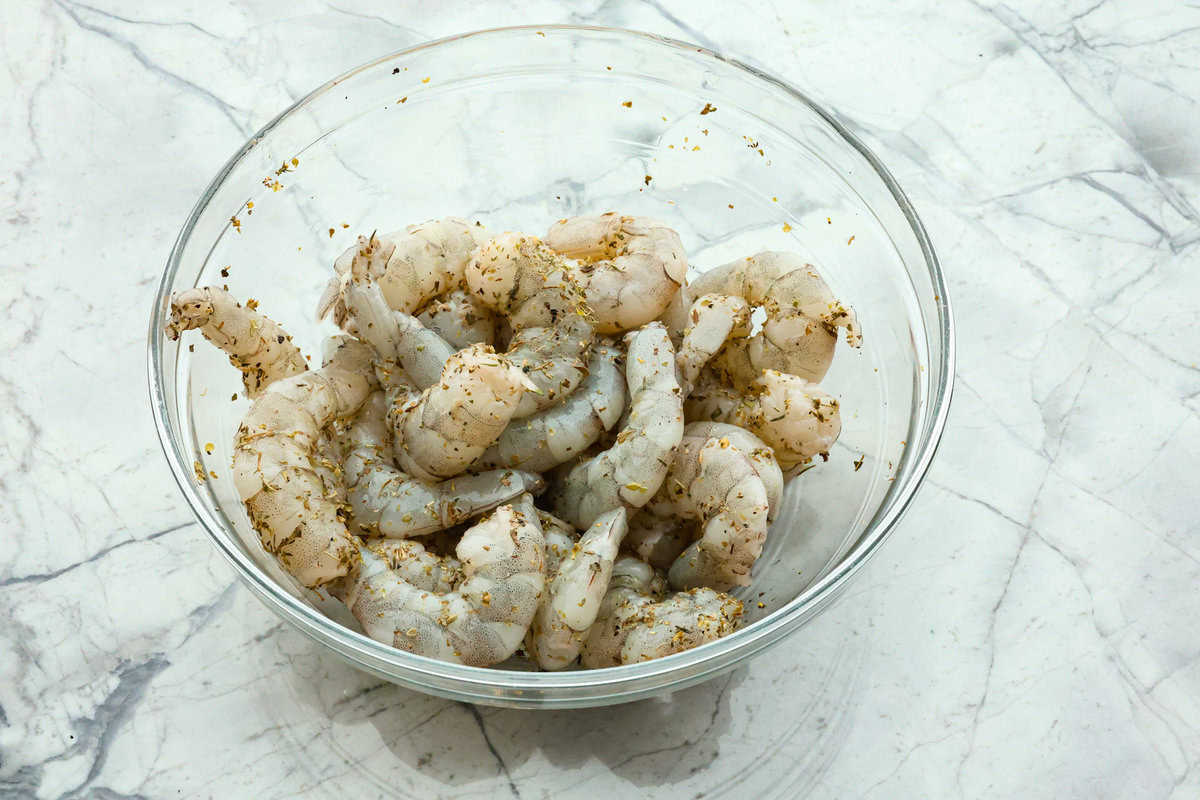 Marry Me Shrimp Pasta dazzles with robust Italian flavors. It's ready in just 30 minutes, and the creamy sauce, brimming with fresh herbs and spices, could very well lead to a marriage proposal after your first bite! Overhead shot of a bowl of raw seasoned shrimp.