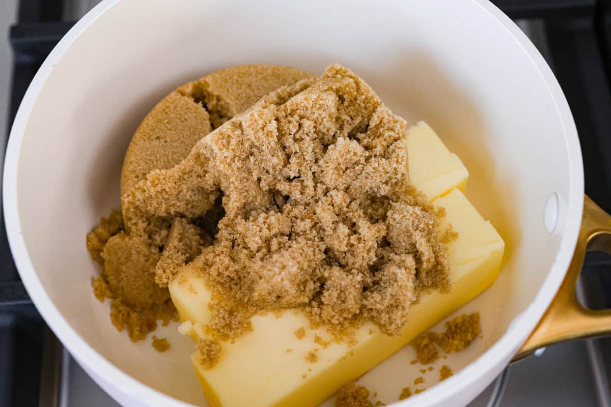 S'mores crack is a quick way to enjoy the classic s'more experience without a campfire. Featuring a buttery graham cracker crust, rich melted chocolate, and toasted marshmallows, this treat will quickly become a family favorite. Overhead shot of a bowl with two sticks of butter covered with a pile of brown sugar.