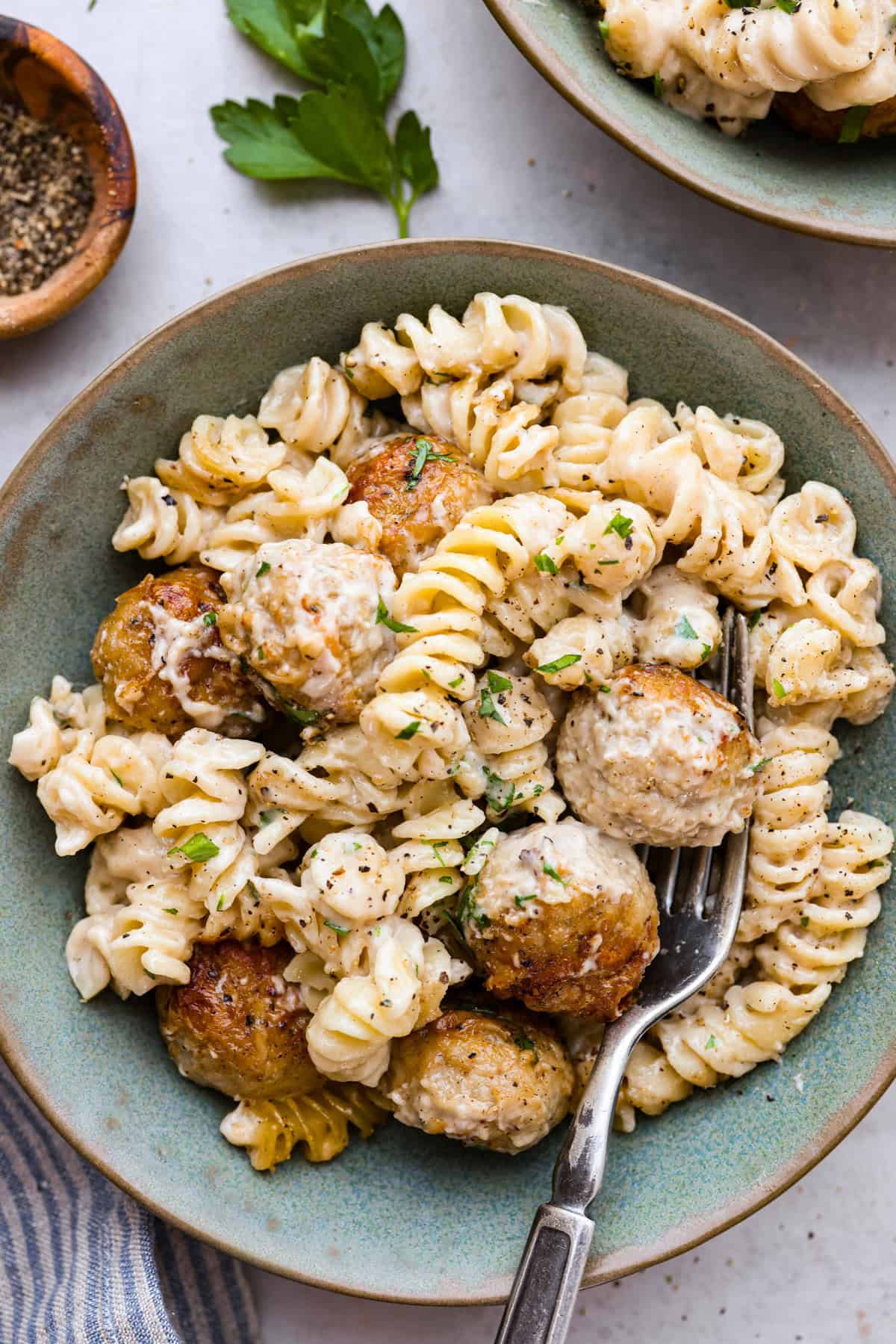 Swedish Meatball Casserole is a classic comfort meal the whole family will enjoy! Tender meatballs are layered over perfectly cooked pasta and baked in a rich, creamy gravy. This dinner recipe is easy enough to make during the week but also deliciously impressive for entertaining! Overhead shot of a pile of plated Swedish meatball casserole.
