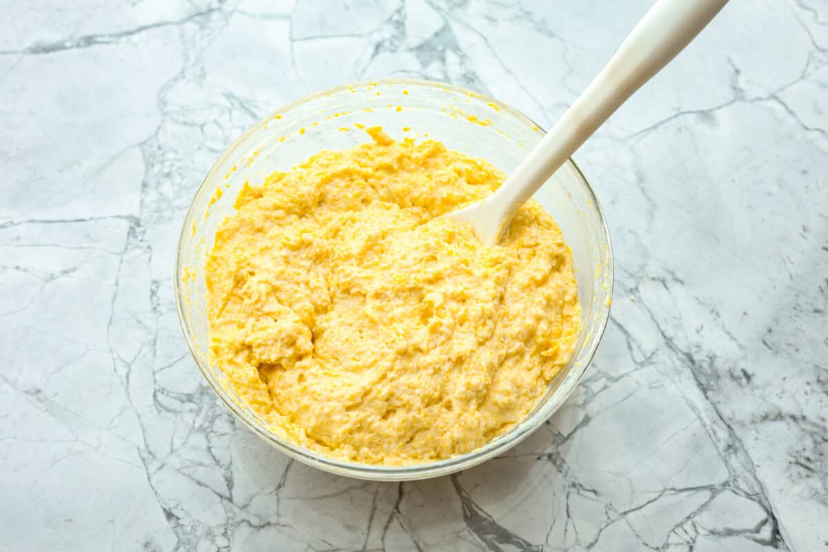 Overhead shot of cornbread batter in glass bowl. 