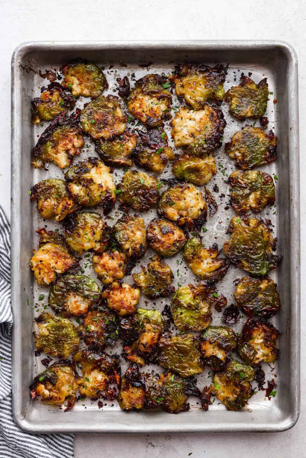 Overhead shot of roasted smashed Brussels sprouts on a baking sheet. 