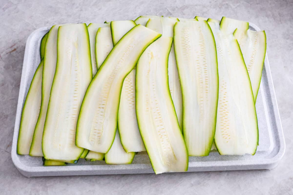 Angle shot of zucchini ribbons on cutting board. 