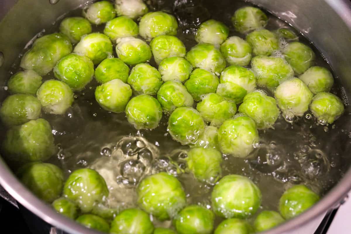 Irresistibly crispy Smashed Brussels Sprouts are simple to make, loaded with delicious flavor, and have the best crunchy texture. These pair well with almost any protein and will definitely upgrade your side dish game! Overhead shot of Brussels sprouts being boiled in water.