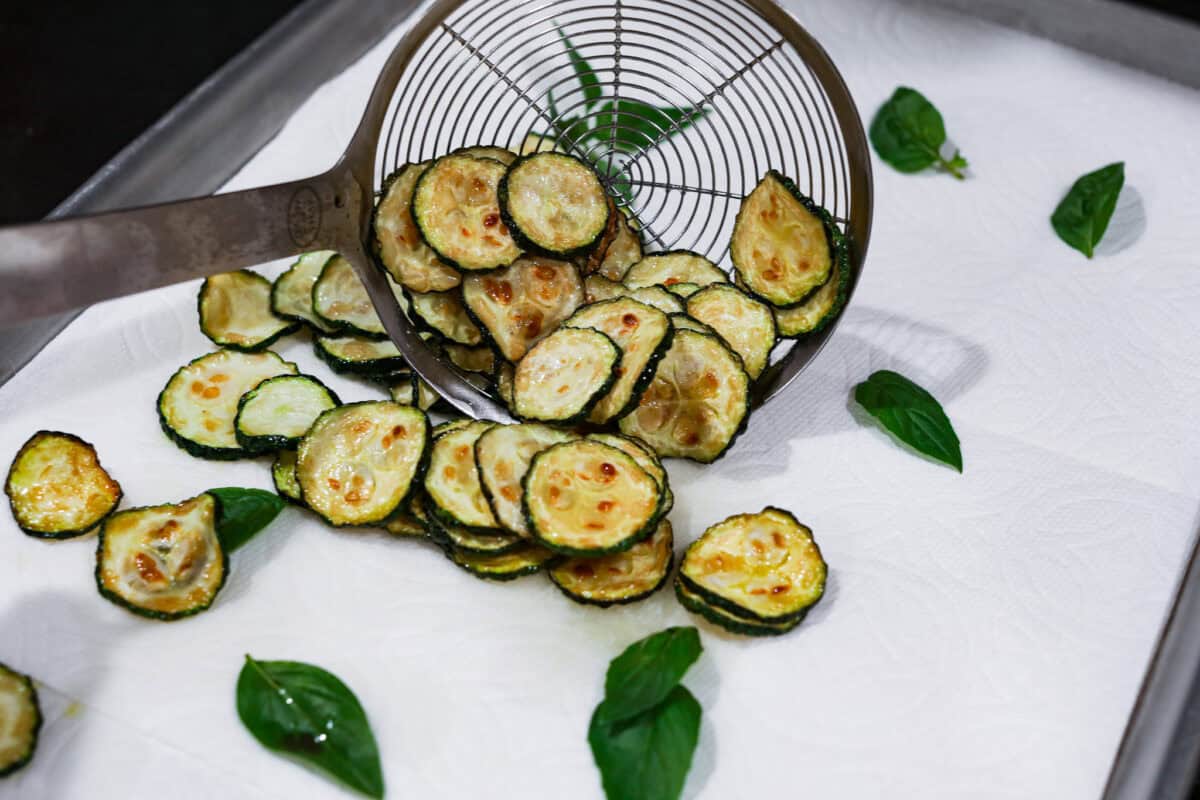 Second photo of the pasta and basil placed on a sheet pan lined with paper towels.