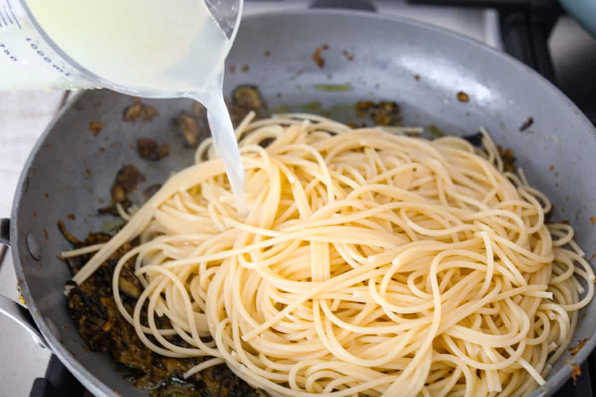 Sixth photo of the pasta and pasta water added to the skillet.