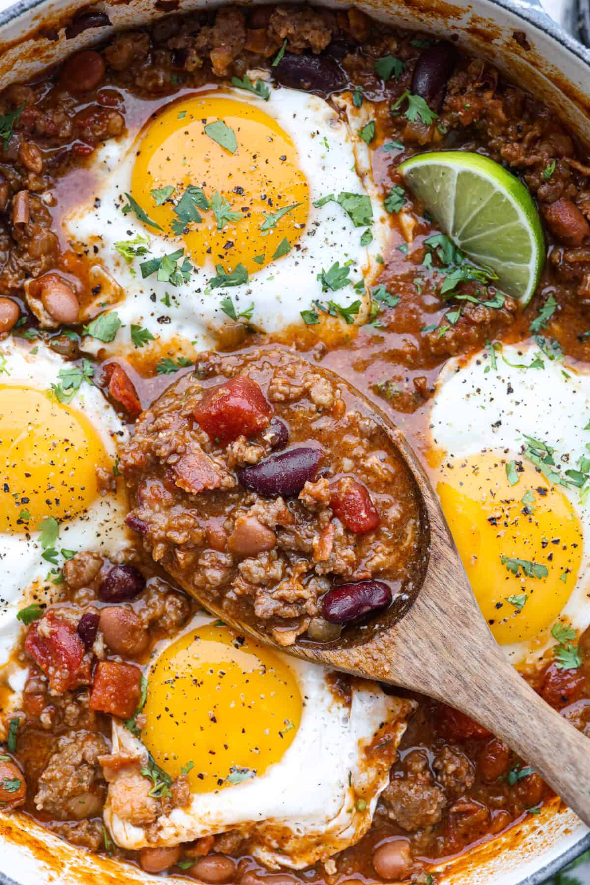 Close up shot of someone taking a scoop of breakfast chili out of the pot. 