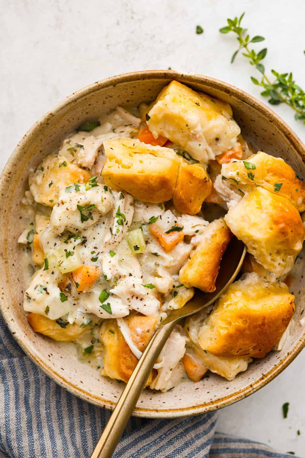 Chicken pot pie casserole is a fun twist on the classic pot pie. It's made with buttery biscuit dough, tender chicken, crunchy veggies, and the most delicious creamy sauce loaded with incredible seasoning. Comfort food at its finest! Overhead shot of plated chicken pot pie casserole.
