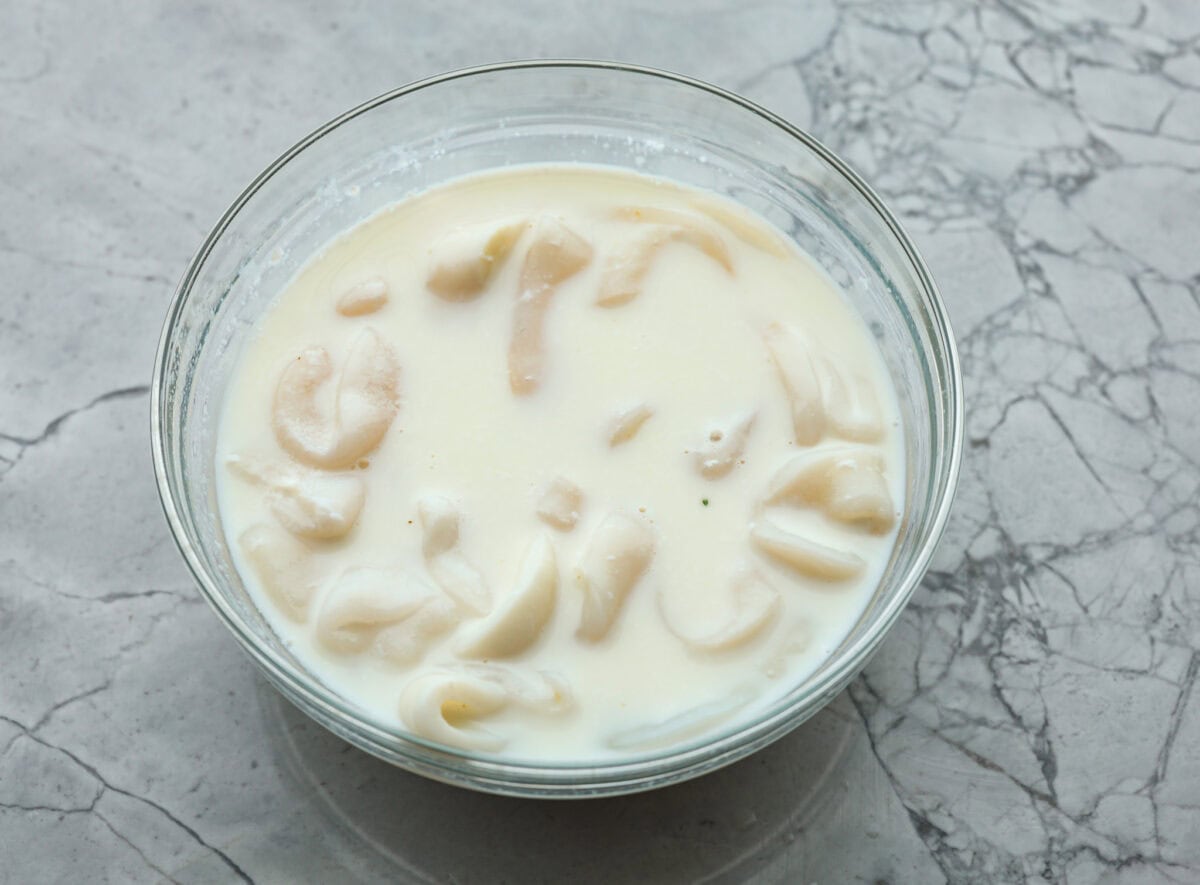 Overhead shot of calamari soaking I’m a milk and lemon juice mixture. 