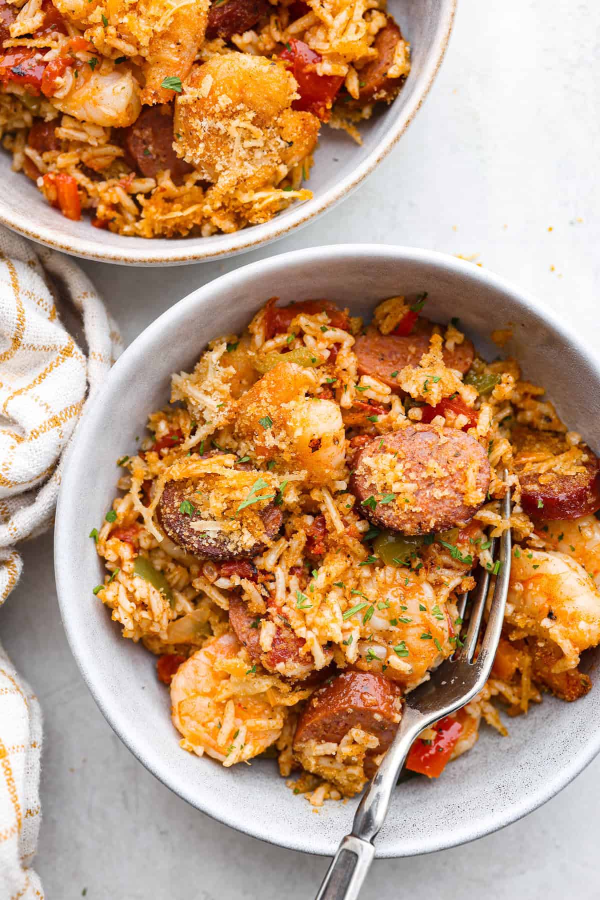 This delicious Louisiana Casserole has become an instant favorite in our house! It has all of the delicious flavors of a jambalaya in an easy-to-make casserole. Tasty andouille sausage, shrimp, veggies, rice and cajun seasoning come together for a complete meal on the table in just 40 minutes! Overhead shot of plated Louisiana casserole.