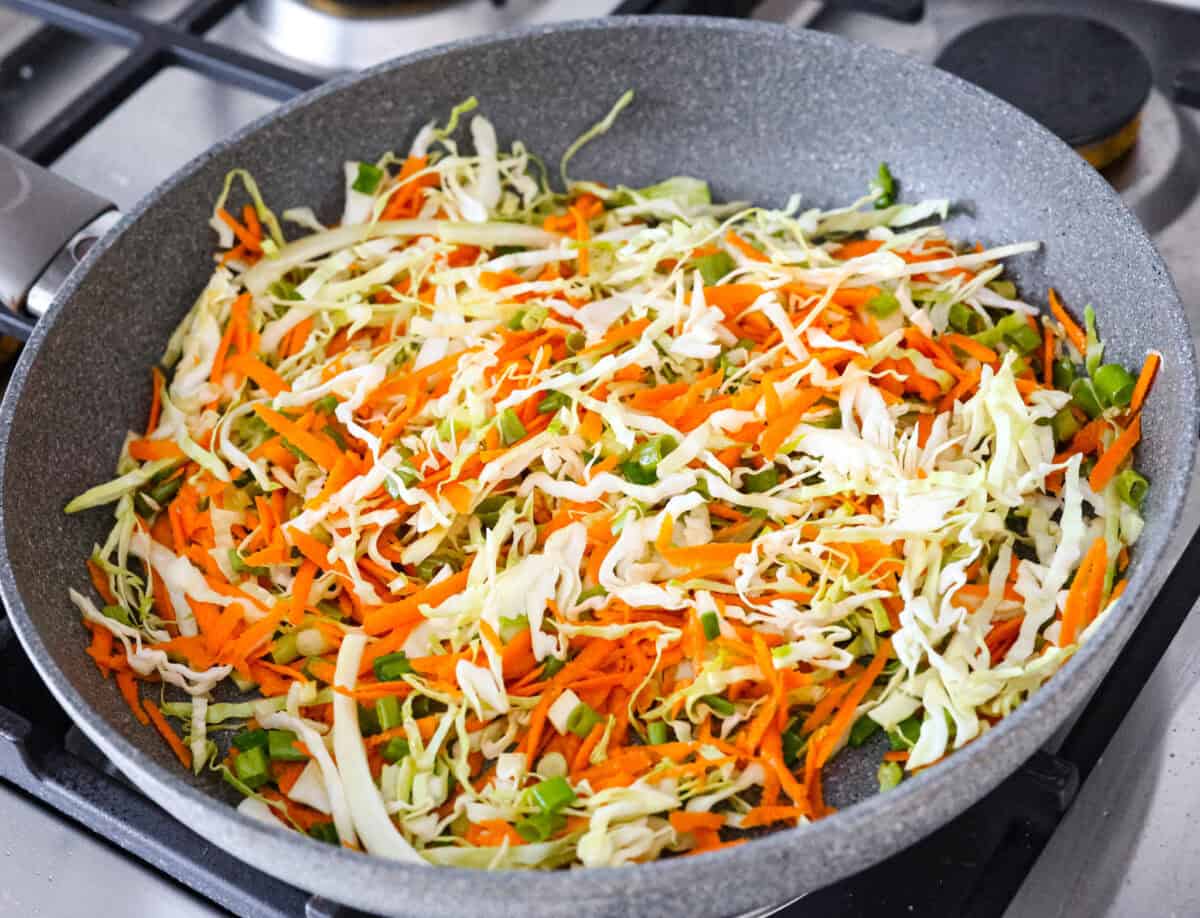 Overhead shot of vegetables cooking in a skillet.