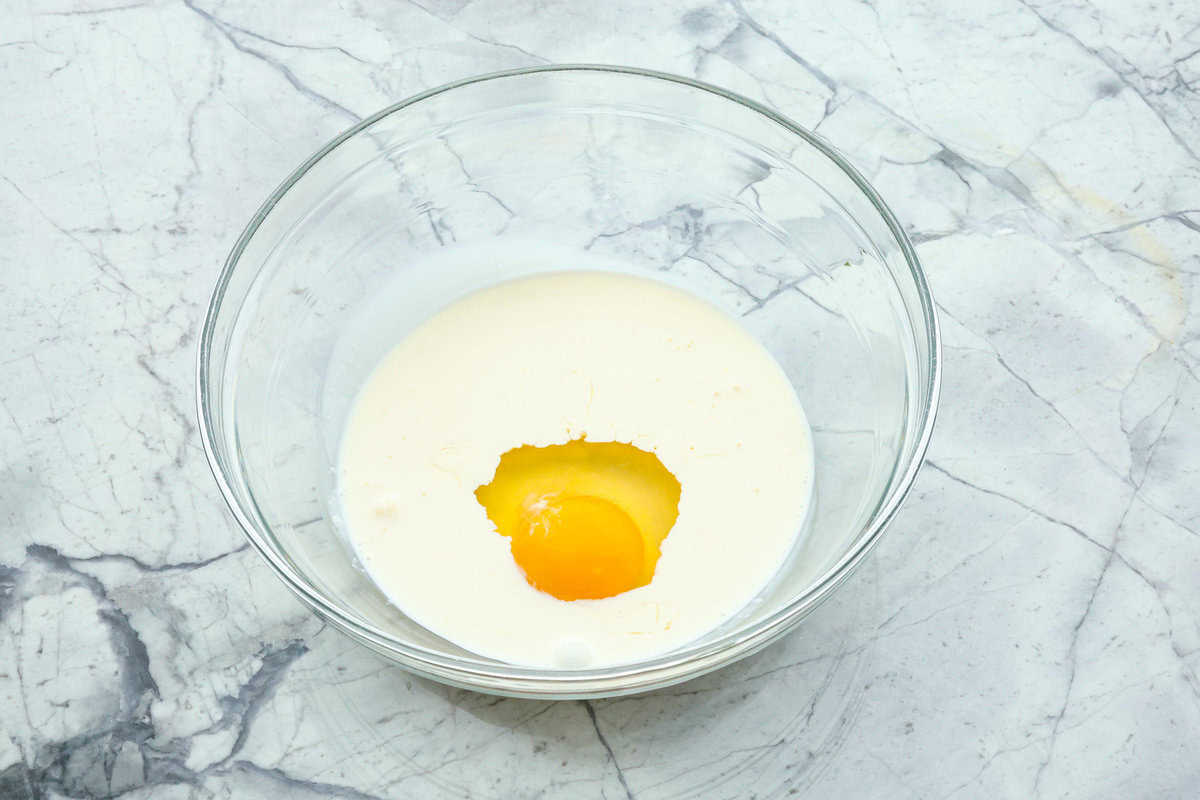 Smothered chicken is a flavorful comfort food full of rich, creamy gravy, tender chicken cutlets, and savory mushrooms. Perfect on its own or paired with mashed potatoes, rice or pasta, you're family will definitely want this on the weekly meal plan. Overhead shot of cream and egg in a glass bowl.