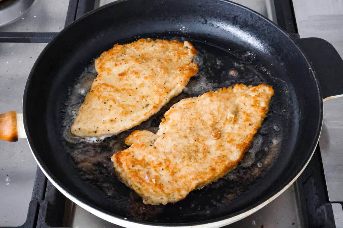 Overhead shot of chicken being cooked in skillet. 