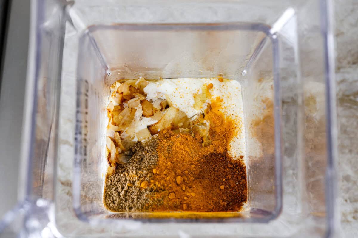 Chicken korma is a traditional Indian chicken dish. It's made with tender chicken smothered in a creamy, wonderfully seasoned sauce. It's so good your family will think you got takeout! Overhead shot of onion mixture with all of the seasonings in a blender.