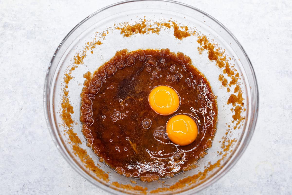 Browned Butter Sugar Cookies are irresistibly thick and chewy with rich flavor, thanks to the addition of browned butter. Even more delicious than the classic, and there's no need to chill the dough! Overhead shot of sugar and butter mixture with egg and egg yolk on top.
