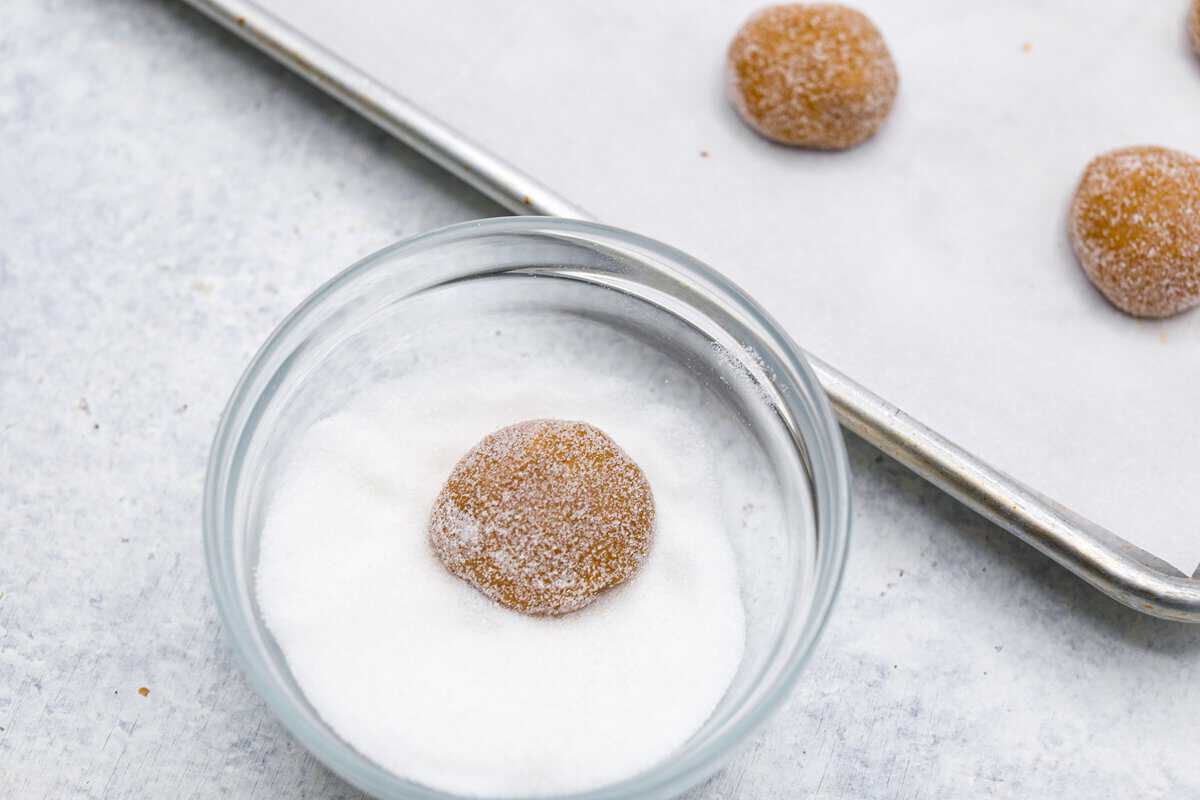 Browned Butter Sugar Cookies are irresistibly thick and chewy with rich flavor, thanks to the addition of browned butter. Even more delicious than the classic, and there's no need to chill the dough! Overhead shot of dough ball being rolled in sugar.