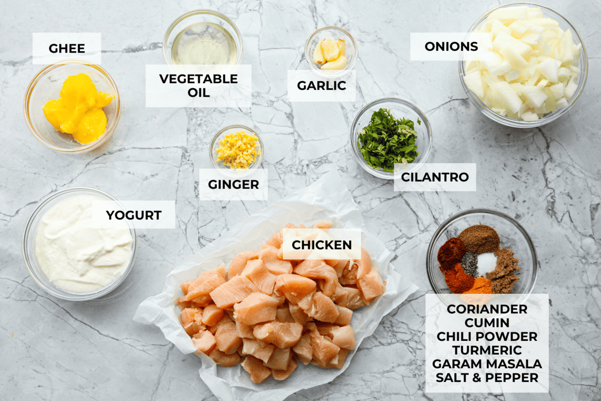 Chicken korma is a traditional Indian chicken dish. It's made with tender chicken smothered in a creamy, wonderfully seasoned sauce. It's so good your family will think you got takeout! Overhead shot of labeled ingredients.