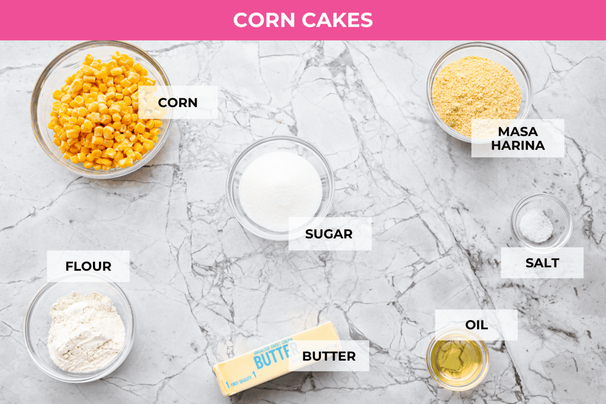 Homemade Sweet Corn Tamale Cakes are an explosion of delicious flavor in every bite! With this easy recipe you can bring this Cheesecake Factory favorite right to your own kitchen. Add the signature topping to really take these to the next level! Overhead shot of labeled corn cakes ingredients.