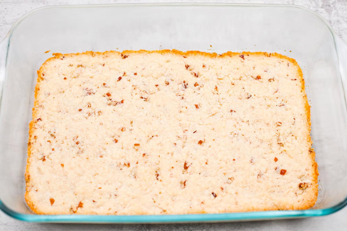 Fall in love with this Pumpkin Delight! A shortbread crust topped with a fluffy cheesecake mixture, a creamy pumpkin layer, and whipped topping. Every bite of this irresistible layered dessert is pumpkin heaven! Second photo of the crust baked in the pan.