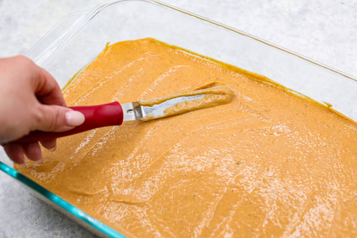 Sixth photo of the pumpkin layer spreading on the cheesecake layer.