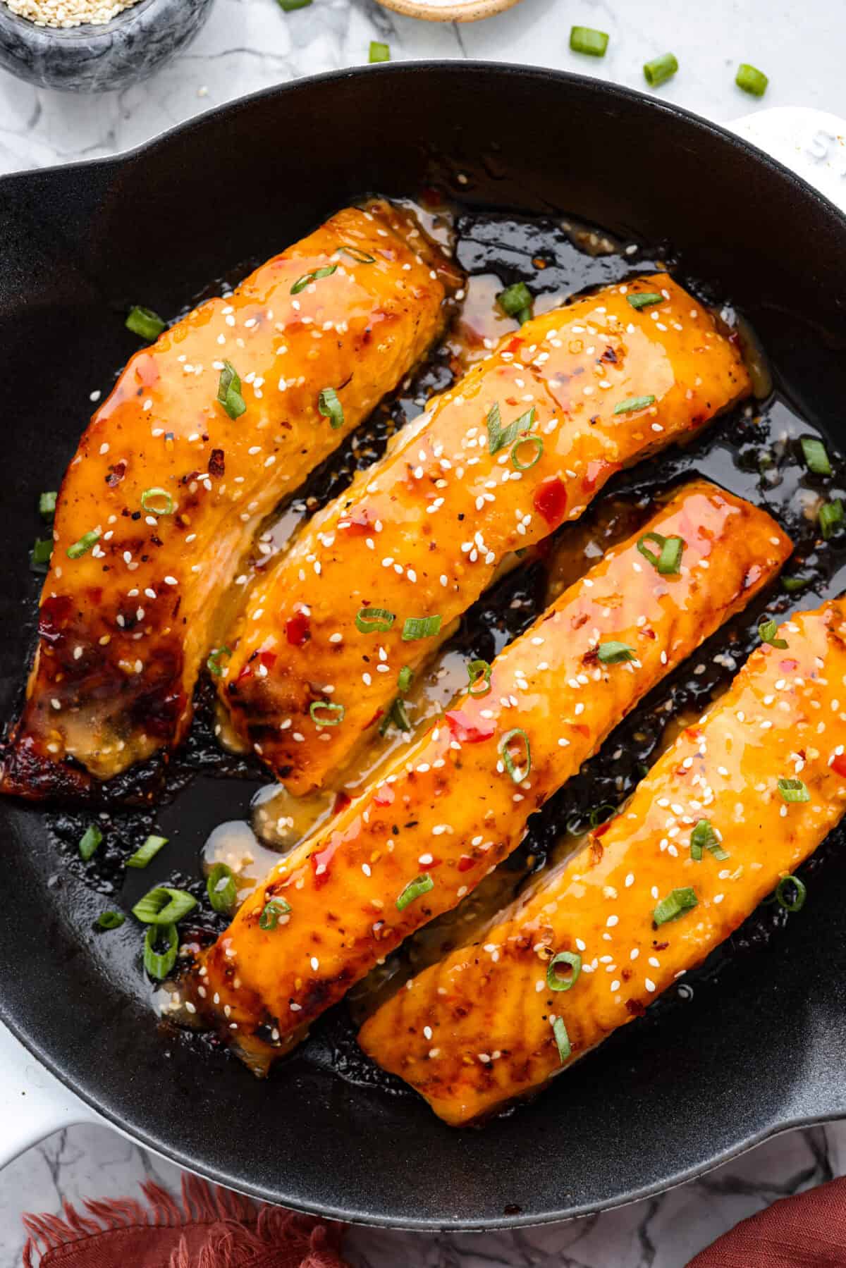 Overhead shot of bang bang salmon in a skillet. 