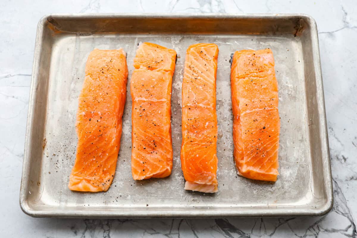 Photo of salmon filets on a baking sheet. 