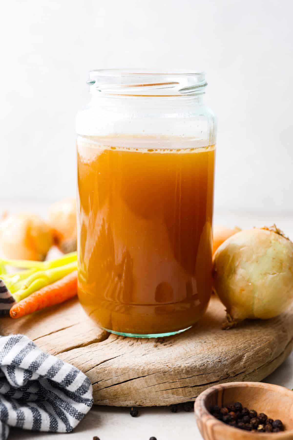 Side shot of a mason jar with homemade bone broth in it. 