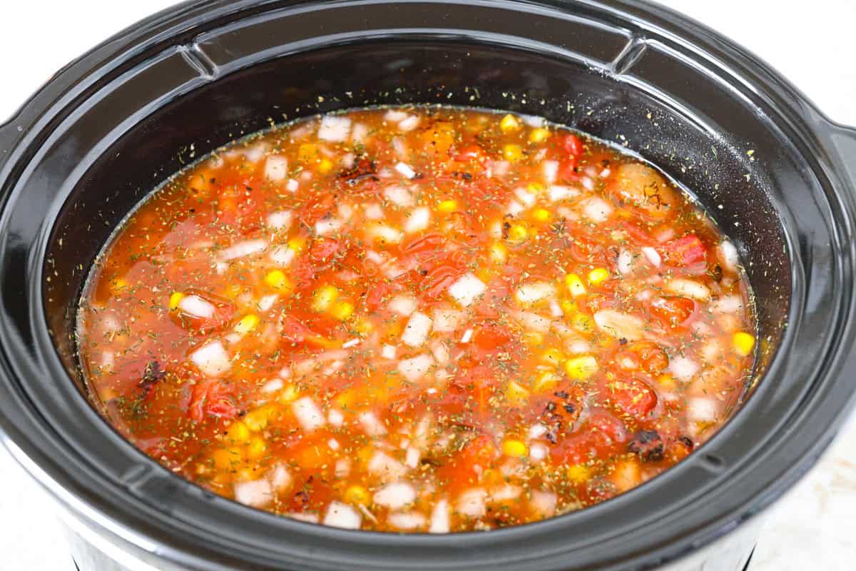 Crockpot buffalo chicken chili is a buffalo wing lover's dream. It has a tangy, fiery buffalo hot sauce base mixed with shredded chicken, smooth cream cheese, tender beans, and vegetables. If you love buffalo wings, you will love this chili! Overhead shot of all the ingredients stirred up in the crockpot.