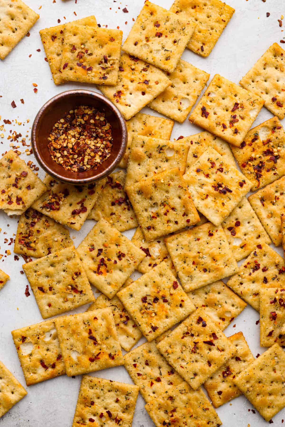 Overhead shot of fire crackers on a counter top with a bowl of red pepper flakes in a small bowl. 