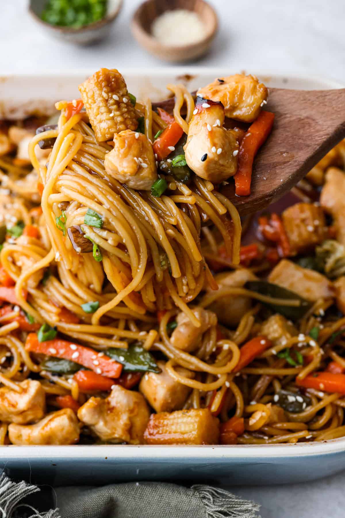 Honey Sesame Chicken Noodle Bake is the perfect dinner solution when you need something incredibly tasty and totally fuss-free! This is a complete meal with delicious Asian flavors in one pan, without needing to pre-cook anything. Close up shot of a scoop of honey sesame chicken noodle bake.