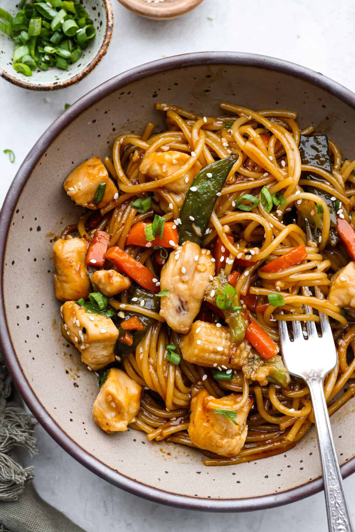 Honey Sesame Chicken Noodle Bake is the perfect dinner solution when you need something incredibly tasty and totally fuss-free! This is a complete meal with delicious Asian flavors in one pan, without needing to pre-cook anything. Overhead shot of plated honey sesame chicken noodle bake.