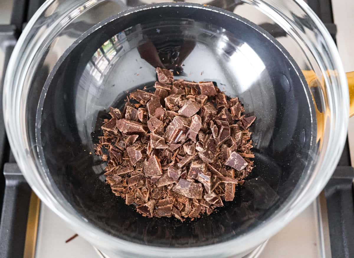 Learn how to temper chocolate for all your chocolate dipping and candy-making needs! Tempering chocolate can be intimidating but my how-to guide will help you every step of the way. Third photo of the chocolate added to the glass bowl to melt and temper.