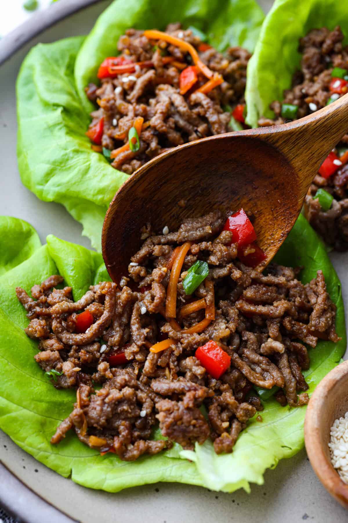 Close up shot of Korean beef lettuce wraps being assembled. 