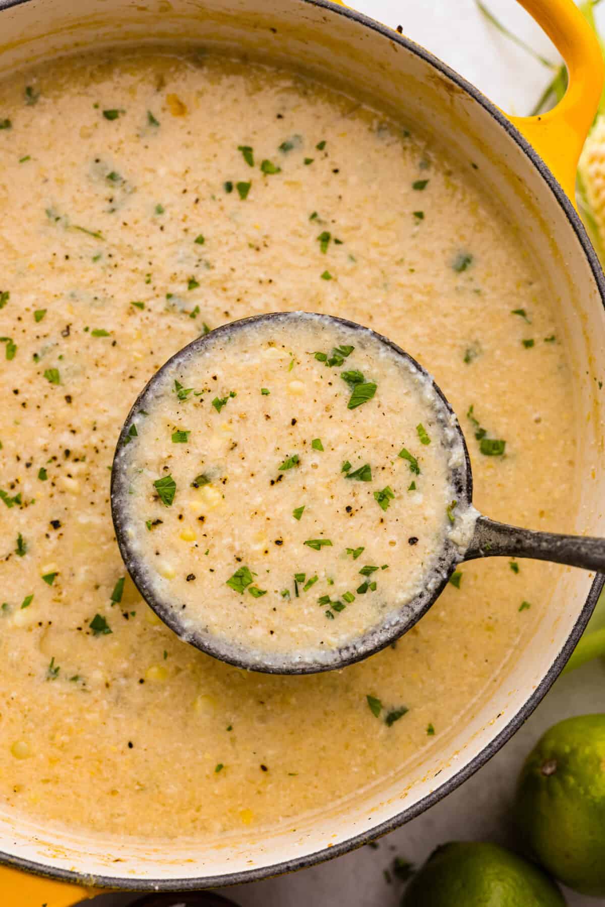 Overhead shot of Mexican street corn in a pot with a ladle. 