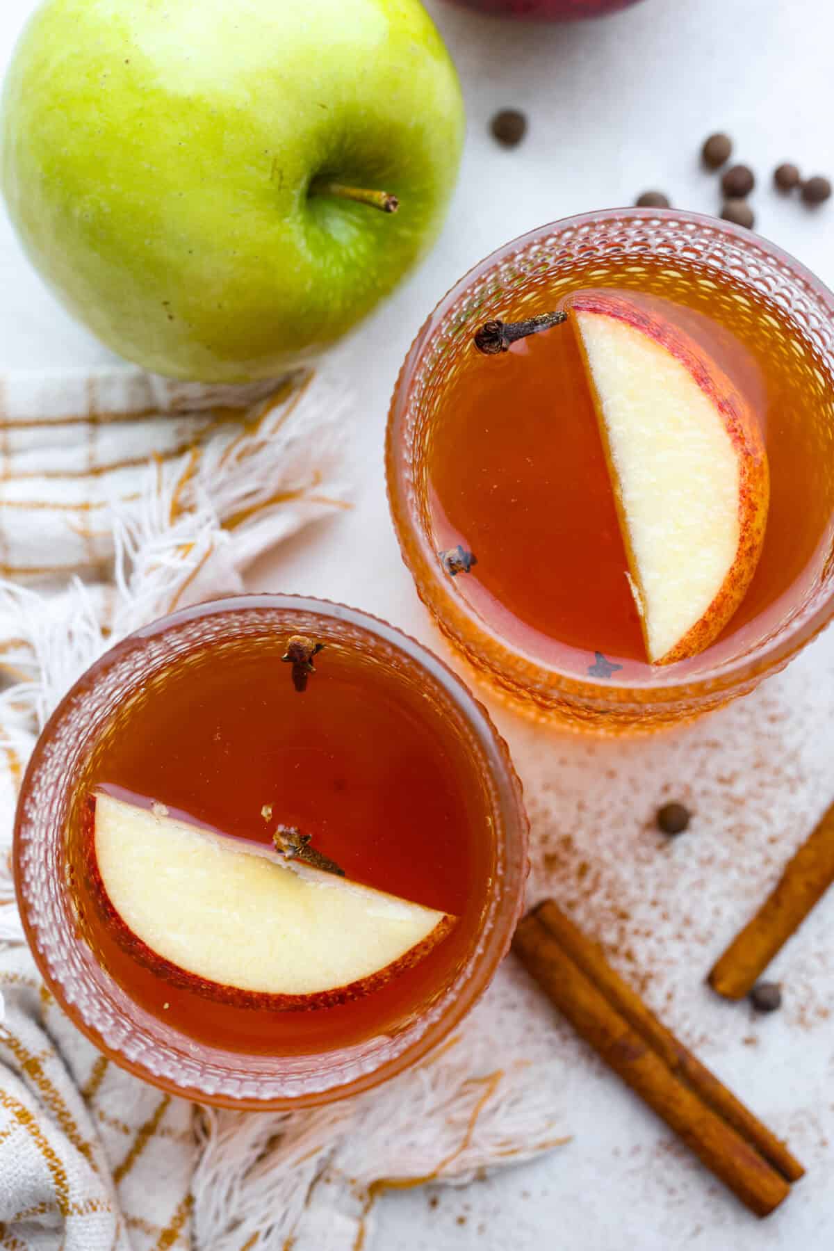 Overhead shot of two glasses with mulled cider in them. 