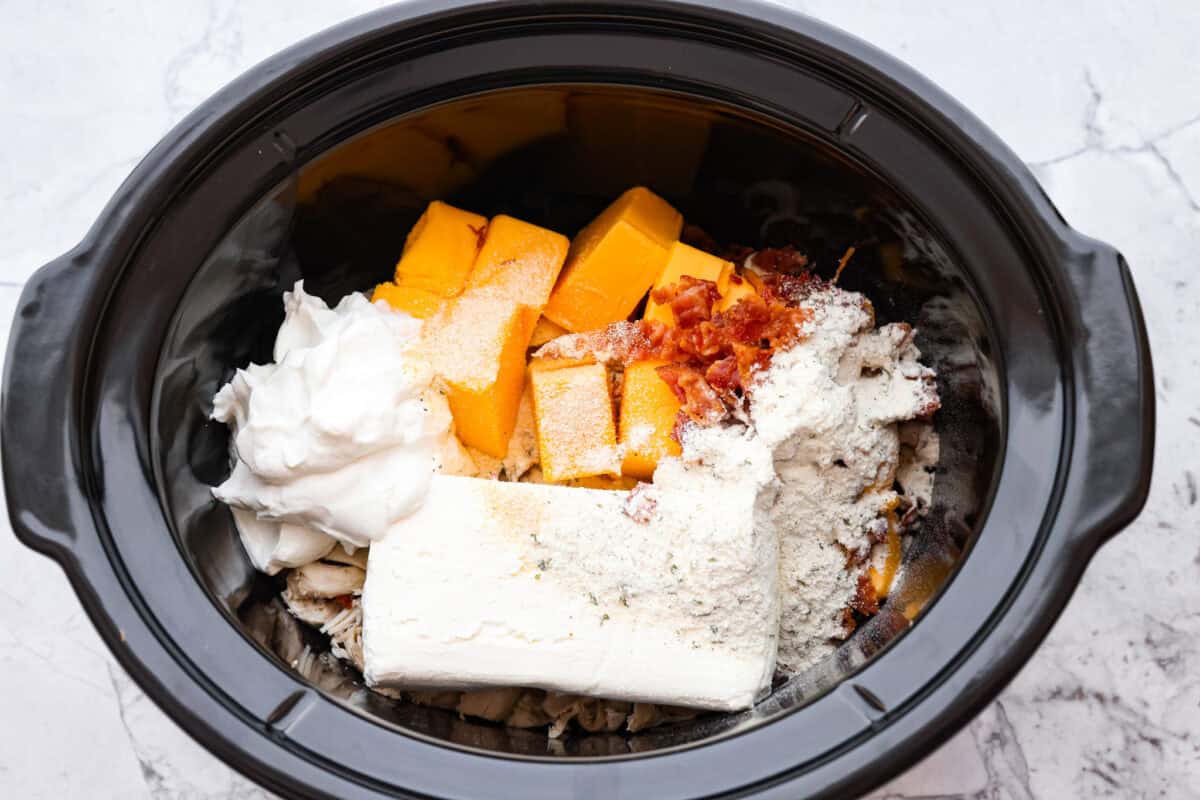 Overhead shot of all of the ingredients dumped in a slow cooker. 