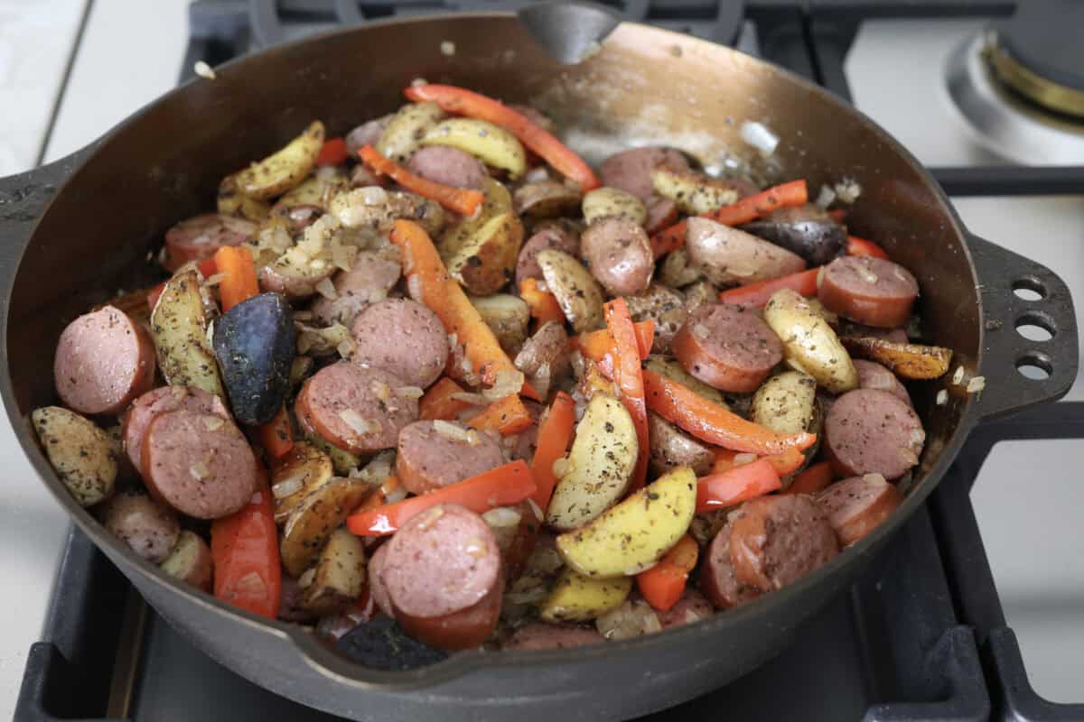 Fifth photo of the sausage and potato skillet heating through on the stove.