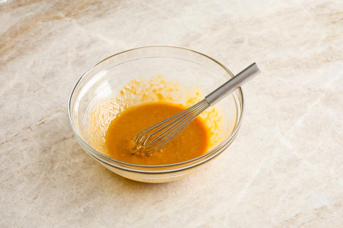 Angle shot of the marinade ingredients whisked in a bowl. 