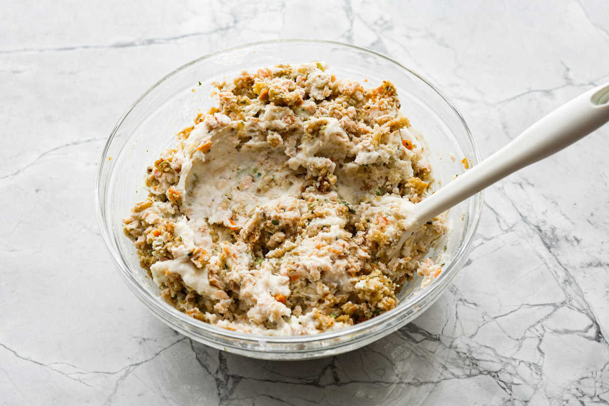 Angle shot of turkey, mashed potatoes, breadcrumbs and stuffing mixed in a bowl.