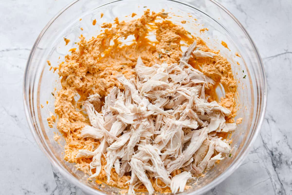 Third photo of the shredded chicken added to the cream cheese mixture.