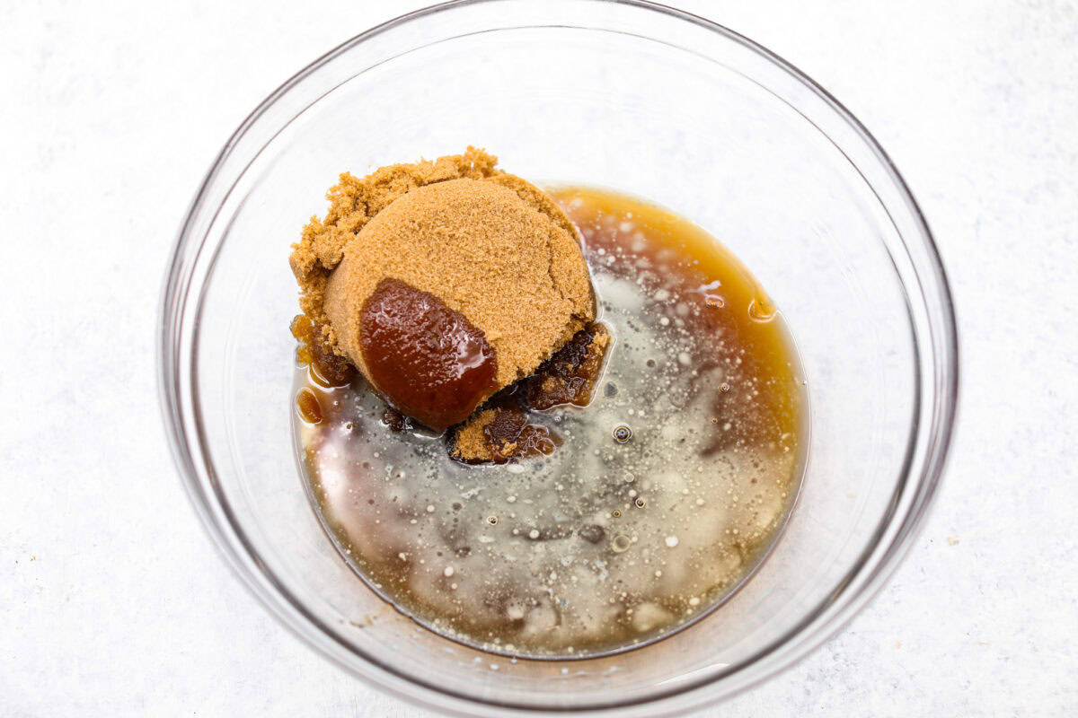 Overhead shot of butter, sugar, corn syrup in a glass bowl. 