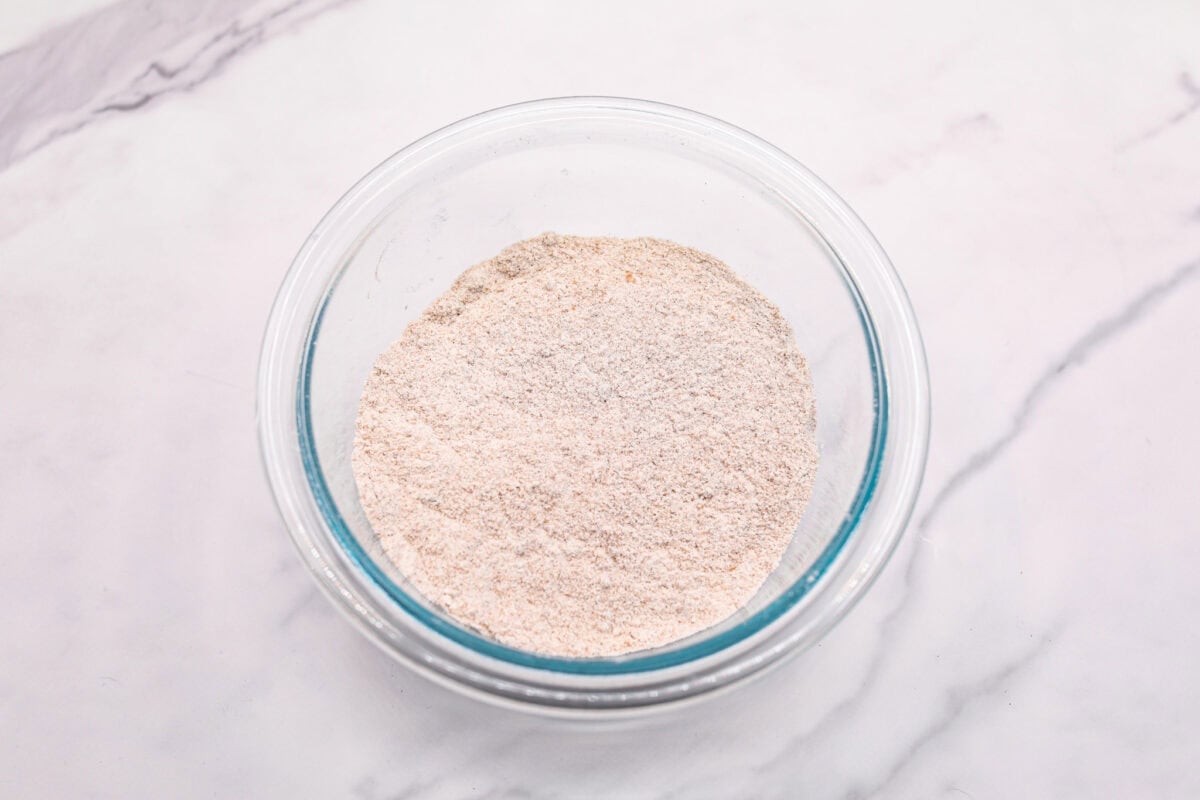 Overhead shot of flour, sugars, cinnamon, and salt in a glass bowl. 