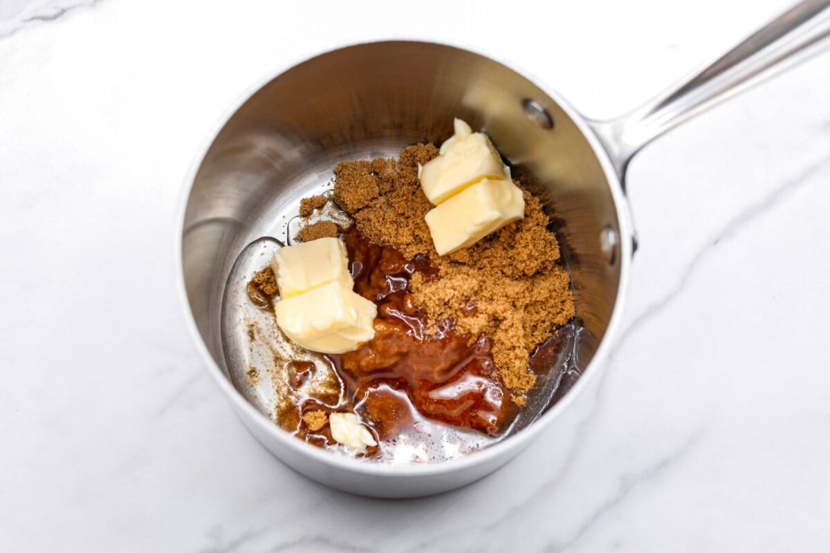 Overhead shot of butter, brown sugar, and corn syrup in a sauce pan. 