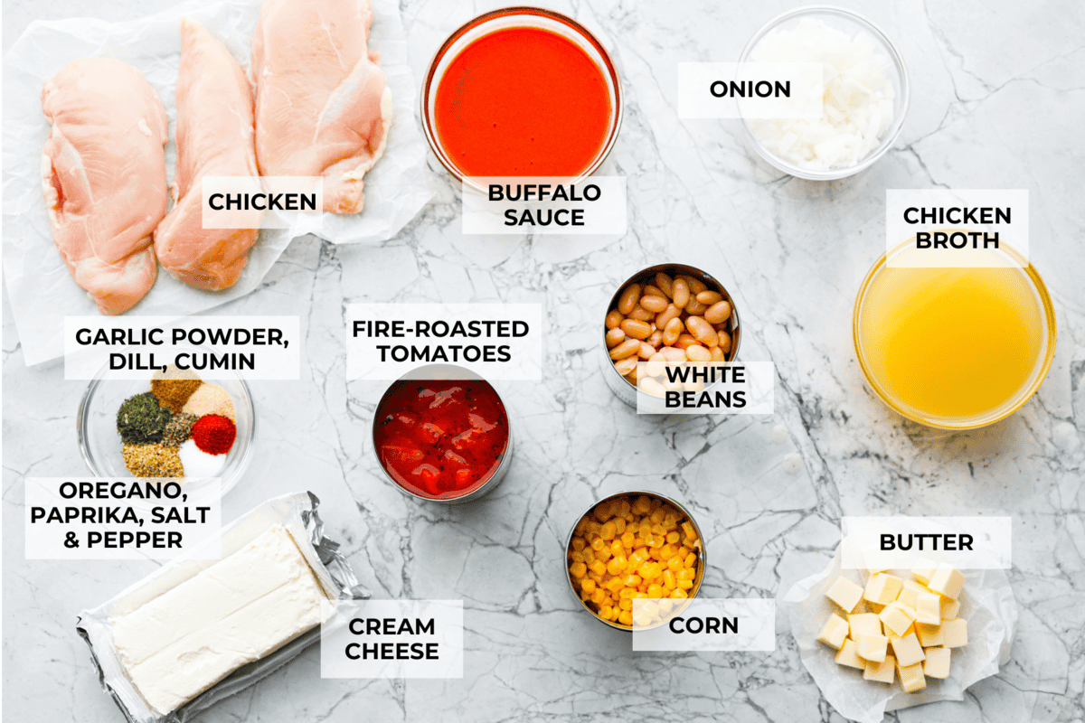 Crockpot buffalo chicken chili is a buffalo wing lover's dream. It has a tangy, fiery buffalo hot sauce base mixed with shredded chicken, smooth cream cheese, tender beans, and vegetables. If you love buffalo wings, you will love this chili! Overhead shot of labeled ingredients.