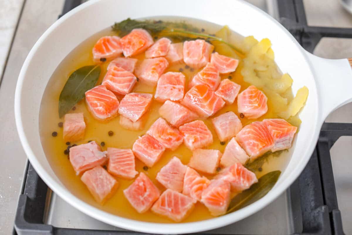 Overhead shot of salmon in the white wine reduction. 