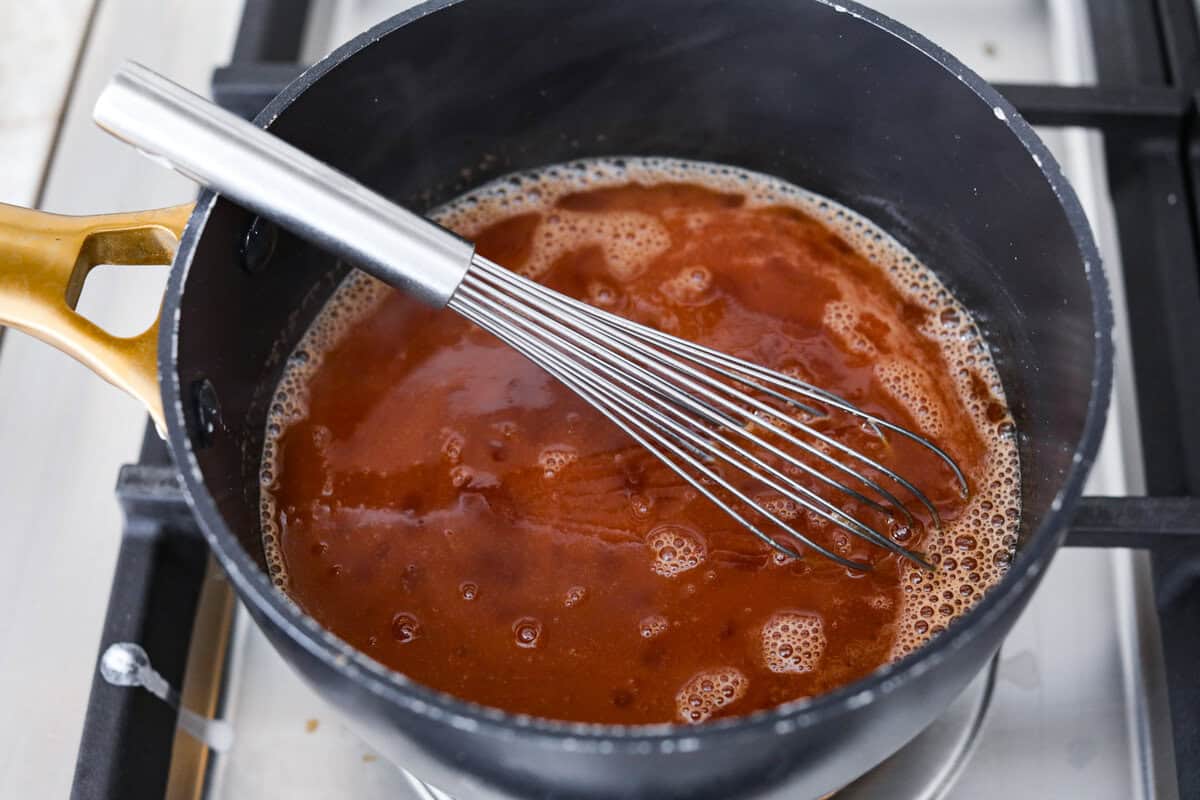 These sweet and sour wings are the perfect appetizer to serve for your next party, game day, or after-school snack. They are baked to crispy perfection and then doused in a sticky, sweet, and sour sauce. Overhead shot of sauce ingredients combined in a pan.