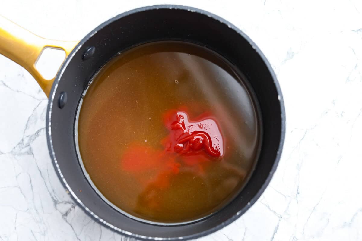 These sweet and sour wings are the perfect appetizer to serve for your next party, game day, or after-school snack. They are baked to crispy perfection and then doused in a sticky, sweet, and sour sauce. Overhead shot of pineapple juice, vinegar, brown sugar, ketchup, and soy sauce, in a sauce pan.